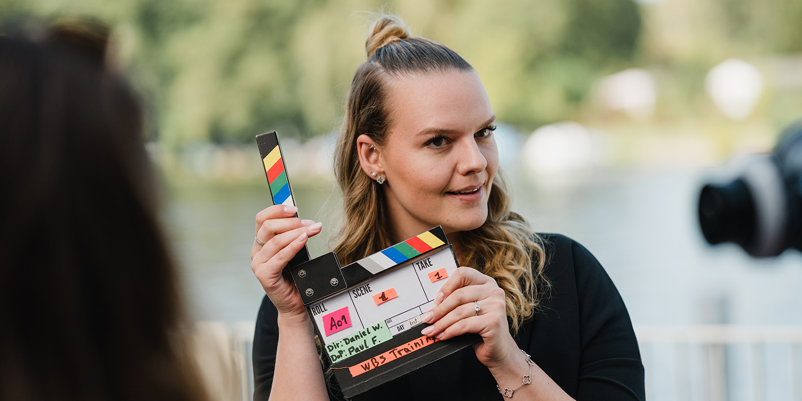 Frau mit Regieklappe in Interviewsituation